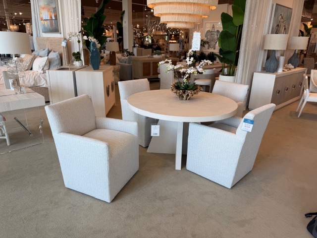 Round table with 4 light colored upholstered dinner chairs